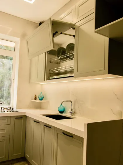 This lift-up cabinet includes a dish-draining rack, a practical solution for Indian homes where dishes are often hand-washed. It keeps the counter dry and clutter-free.