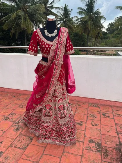 This is a glimpse of one of my premium bridal lehengas available for rent. The intricate velvet embroidery and rich magenta color make it a luxurious choice for a bride on her wedding day.
