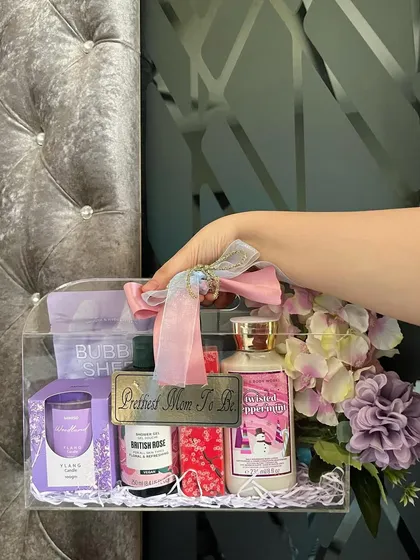 This hand-held shot shows the portability and stylish design of our acrylic hamper. It's a gift that looks as good as the thoughtful items inside it.