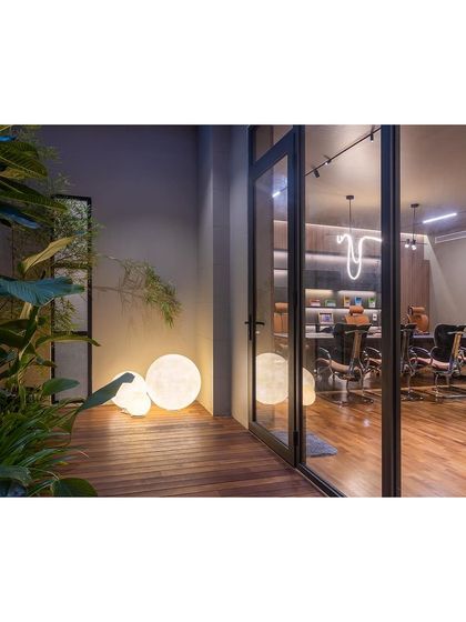 This view from the outdoor deck into an office space highlights my focus on seamless indoor-outdoor connections. The spherical floor lamps add a soft, ambient glow to the deck area in the evening.