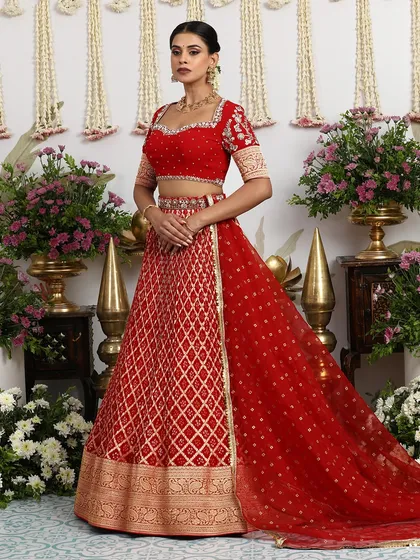A timeless heirloom, this classic red silk lehenga is a tribute to bridal tradition. The rich golden embroidery and regal Banarasi weave are crafted for a bride's most cherished day, promising a look of unparalleled grace and splendor.