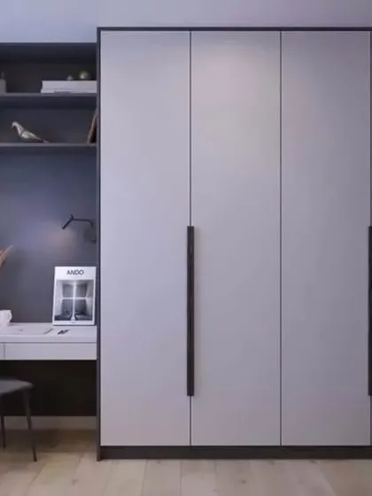 A minimalist wardrobe with an integrated study desk. The dark grey and black color scheme is sleek and modern, perfect for a contemporary bedroom or home office.