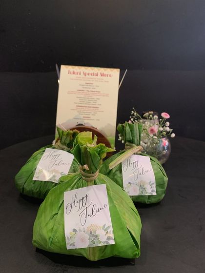 Parcels of food wrapped in banana leaves with "Happy Tuluni" tags, ready to be served to our guests during the festival.