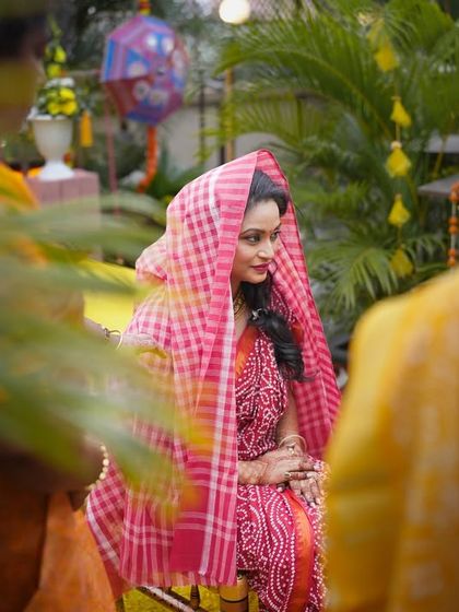 A candid shot of the bride during her Haldi ceremony, covered with a traditional cloth. This photo captures a unique and authentic moment from the ritual.