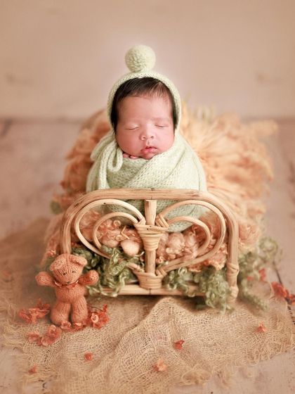Pistachio sweet. The little pom-pom bonnet adds so much character to this shot, perfectly complementing the soft green and peach tones.