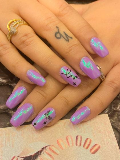 A trendy and cute design on lavender coffin nails. The polish has a subtle chrome effect and is accented with hand-written "love" text, stars, and a butterfly.