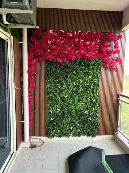 I combine different elements to create your perfect green space. This balcony features a lush vertical garden wall topped with vibrant artificial bougainvillea, demonstrating how I can blend different textures and colors for a unique look.