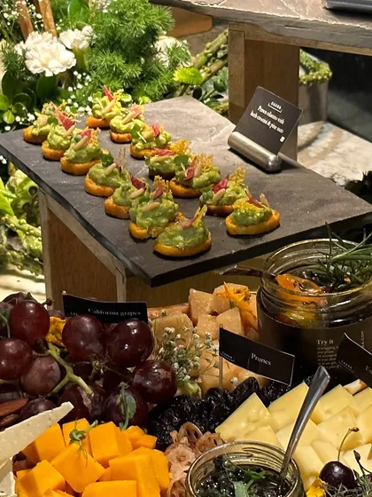 A close-up of a cheese board featuring a variety of cheeses, grapes, and our house-made dips. Our grazing tables are designed to be interactive, allowing guests to create their own perfect pairings.