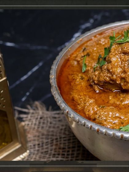 A close-up of our Mutton Korma, showing the thick, textured gravy clinging to the tender pieces of meat.