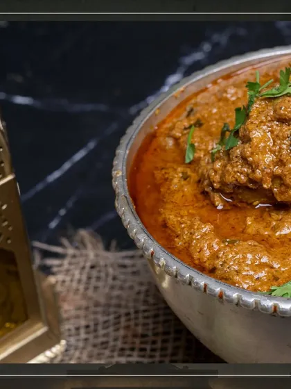 A close-up of our Mutton Korma, garnished with fresh cilantro, ready to be served.
