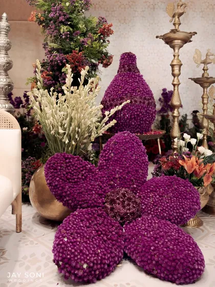 Floral artistry at its best. For the "Garden of Vows" theme, I created these large, sculptural flowers and vases made entirely of deep purple gomphrena blooms, adding a unique and artistic touch to the decor.