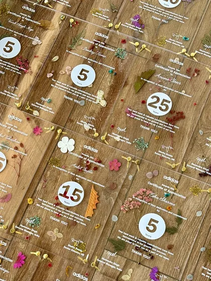 Employee appreciation can be beautiful. For Adidas, I created these unique certificates on acrylic, featuring screen printing, custom calligraphy, and individually arranged pressed flowers. Each piece is a handcrafted work of art, celebrating dedication and achievement in a truly special way.
