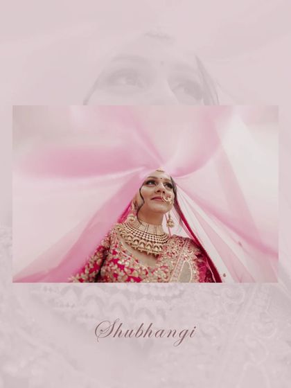An artistic bridal portrait, with the bride looking up through her pink veil, creating a beautiful, colorful, and dreamy effect.