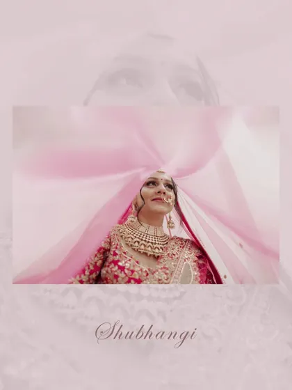 An artistic bridal portrait, with the bride looking up through her pink veil, creating a beautiful, colorful, and dreamy effect.
