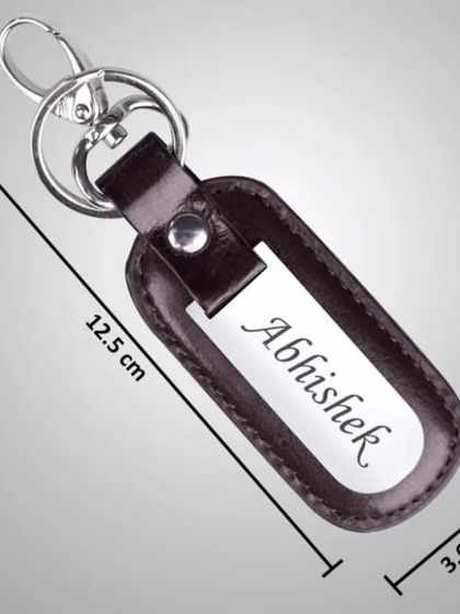 A personalized leather keychain with a metal plate for name engraving, showing its dimensions.