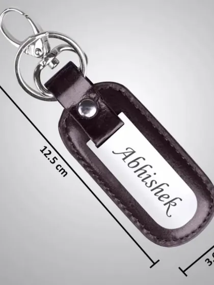 This personalized keychain features a leather holder with a metal plate for name engraving, complete with its dimensions for your reference.