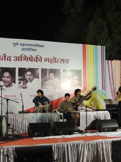 A throwback to a performance at the Pt. Jitendra Abhisheki Mahotsav. This wide shot shows the full band on stage, a lineup of incredible talent creating a fusion of sounds.