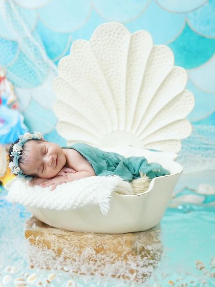 A sleeping mermaid princess. This beautiful side profile shot captures a newborn with a mermaid tail, dreaming in her seashell.