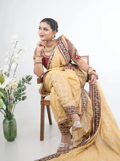 A regal seated pose in the beige Nauvari, perfect for a studio photoshoot.