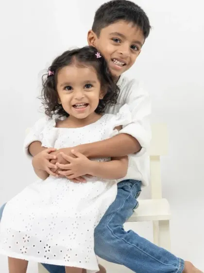 Sometimes, the most powerful photos are the simplest. This timeless portrait of a brother and sister focuses purely on their joyful connection, set against a clean white background to let their personalities shine.
