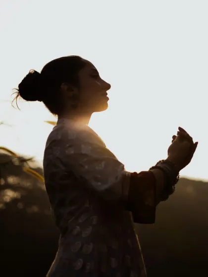 A stunning silhouette of the dancer against the bright sky. This artistic shot uses backlighting to create a dramatic and powerful image that focuses on her form and posture.
