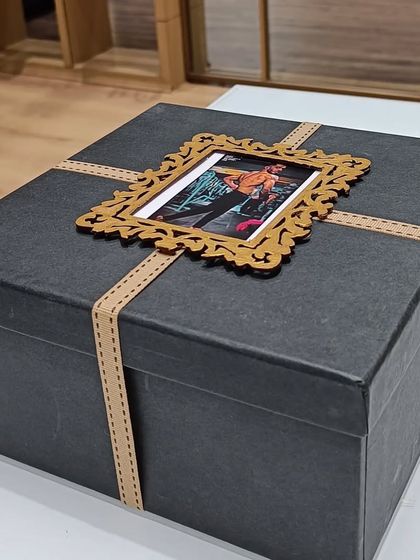The exterior of the black farewell gift box, customized with a photo frame on top.