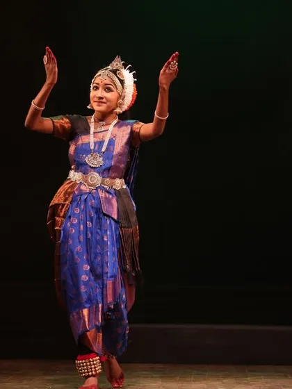 A solo dancer in a moment of quiet grace, her hands held in a delicate mudra, from our Sadhana Classical Dance Festival.
