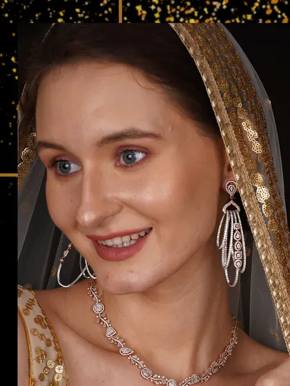 A model, draped in a sequined dupatta, wears a beautiful diamond necklace and earring set.