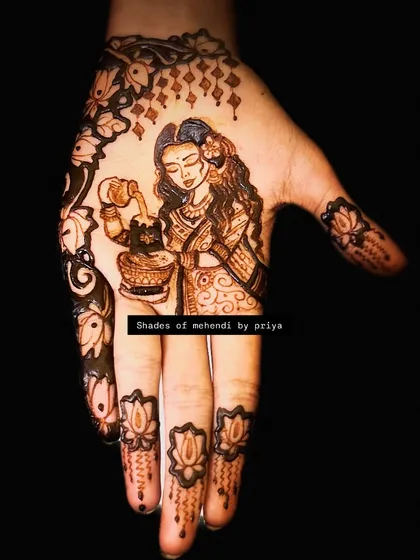 A beautiful depiction of a woman performing a ritual, possibly Tulsi pooja. The design is framed by lotus motifs on the fingers, adding to the spiritual feel.