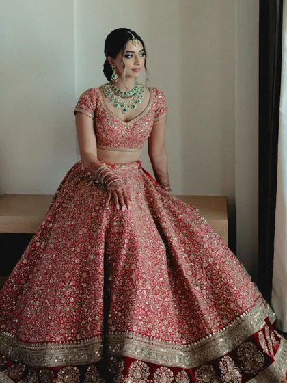 A stunning portrait of the bride in her red lehenga. Our goal is to make sure our brides feel as incredible as they look.