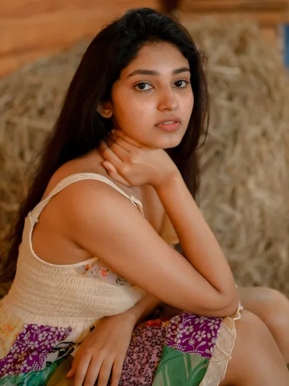 A close-up portrait of actress Rachana Inder in a rustic setting. Her direct gaze and the soft lighting create an intimate and engaging shot.