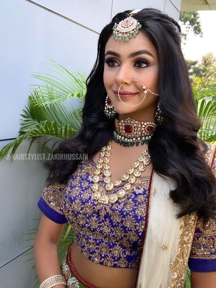 A classic open hairstyle with soft waves and a center part, a timeless look for any wedding event.