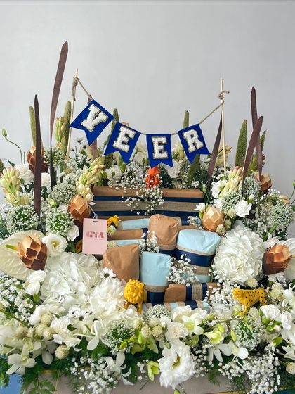 A full view of Veer's luxurious birthday hamper, where gifts are nestled among a stunning display of fresh, natural-toned flowers.