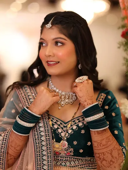 A close-up of the reception bride. Her makeup features a soft smokey eye and a warm lip color, which pairs beautifully with her teal velvet outfit.