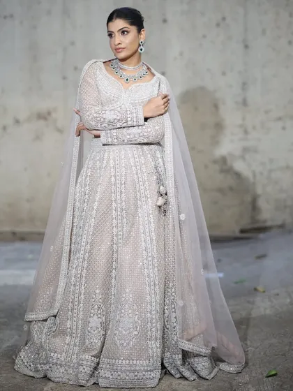 A full view of the elegant emerald and zircon necklace set paired with a flowing white anarkali. This is a perfect example of how to style statement jewellery for a graceful and royal look.