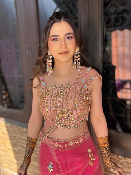 Mehndi ready! This look features soft pink eyeshadow and glowing skin, paired with a trendy half-up hairstyle.