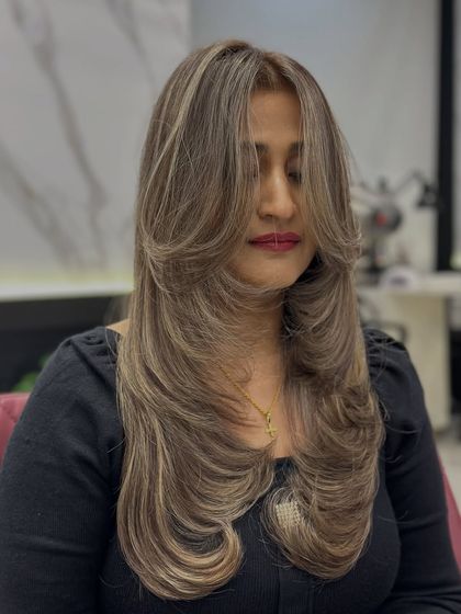 A close-up of the global ash blonde with highlights, showing the intricate layers and cool tones.