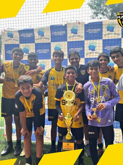 Another team photo of our champions from the Mahim Junior Football Championship, celebrating with their medals and trophy.