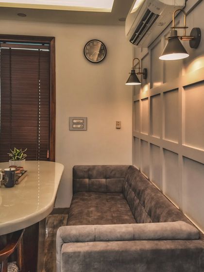 A close-up of the custom-built bench seating in the dining nook, showcasing the comfortable upholstery and the warm ambiance created by the wall-mounted lights.