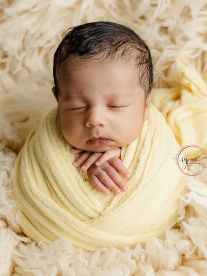 A front-on view of the wrapped newborn, showcasing the perfect symmetry and peacefulness of this popular pose.