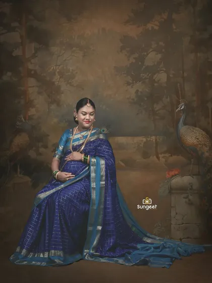 Seated against a painted backdrop of a forest with peacocks, this portrait has a classic, almost vintage painting-like quality.
