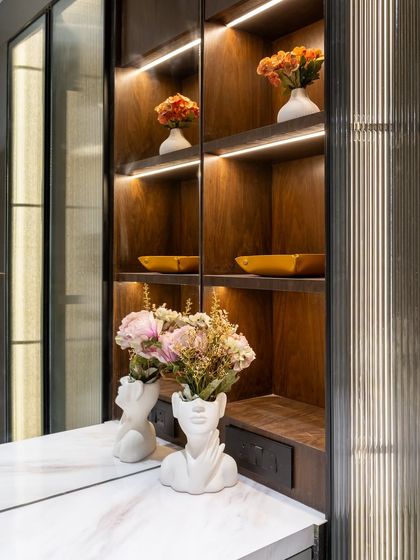This corner proves that even the smallest nooks can be transformed into design statements. The warm wooden shelves, accentuated by subtle strip lighting, provide the perfect stage for curated decor.