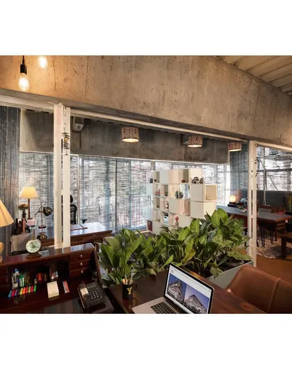 The interior of the studio is a re-adaptable gallery space. The warmth of wood furniture and planters is used to accentuate the raw concrete and glass shell, creating a comfortable and inspiring environment for creative work.
