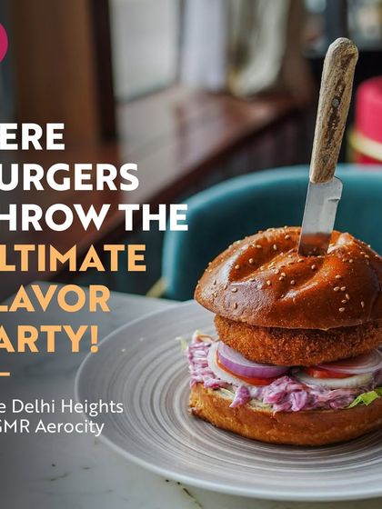 A towering, juicy burger from Cafe Delhi Heights, with a knife holding it all together. This is where burgers throw the ultimate flavour party, promising a satisfying and indulgent meal.
