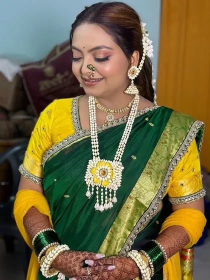 A vibrant Haldi look with a green and yellow saree, accessorized with beautiful fresh floral jewelry.