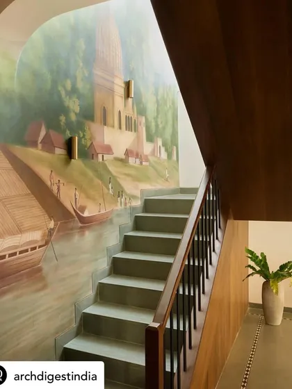 This mural transforms a simple staircase into a journey along a historic riverside. Painted in a soft, sepia-toned style, it tells a story of time and place, making a transitional space feel timeless.