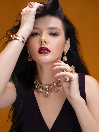 A powerful portrait for a gold and diamond jewelry campaign. The styling, with the bold red lip and windswept hair, creates a feeling of confident, modern glamour.