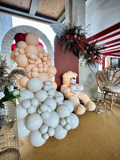 This close-up shows the details of the boho baby shower decor, including the layered balloon clusters, pampas grass, and a custom "Baby on Board" backdrop, all designed to create a cohesive and stylish look.