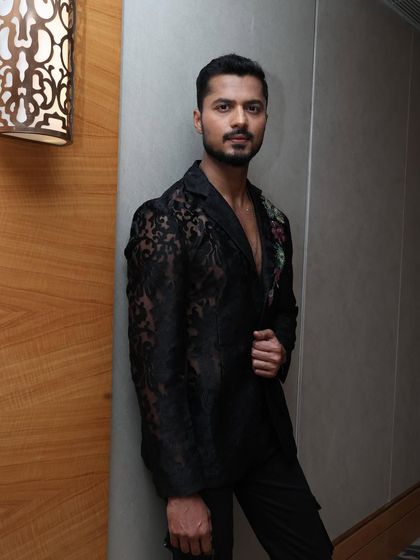 Leaning against a wall, this pose gives a relaxed yet chic vibe to the high-fashion look.