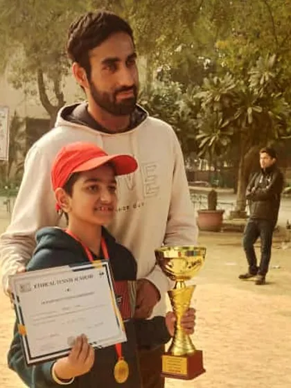 A coach with a young U10 player holding his trophy and certificate. This moment celebrates a third-place finish, proving that every step on the podium is a victory.
